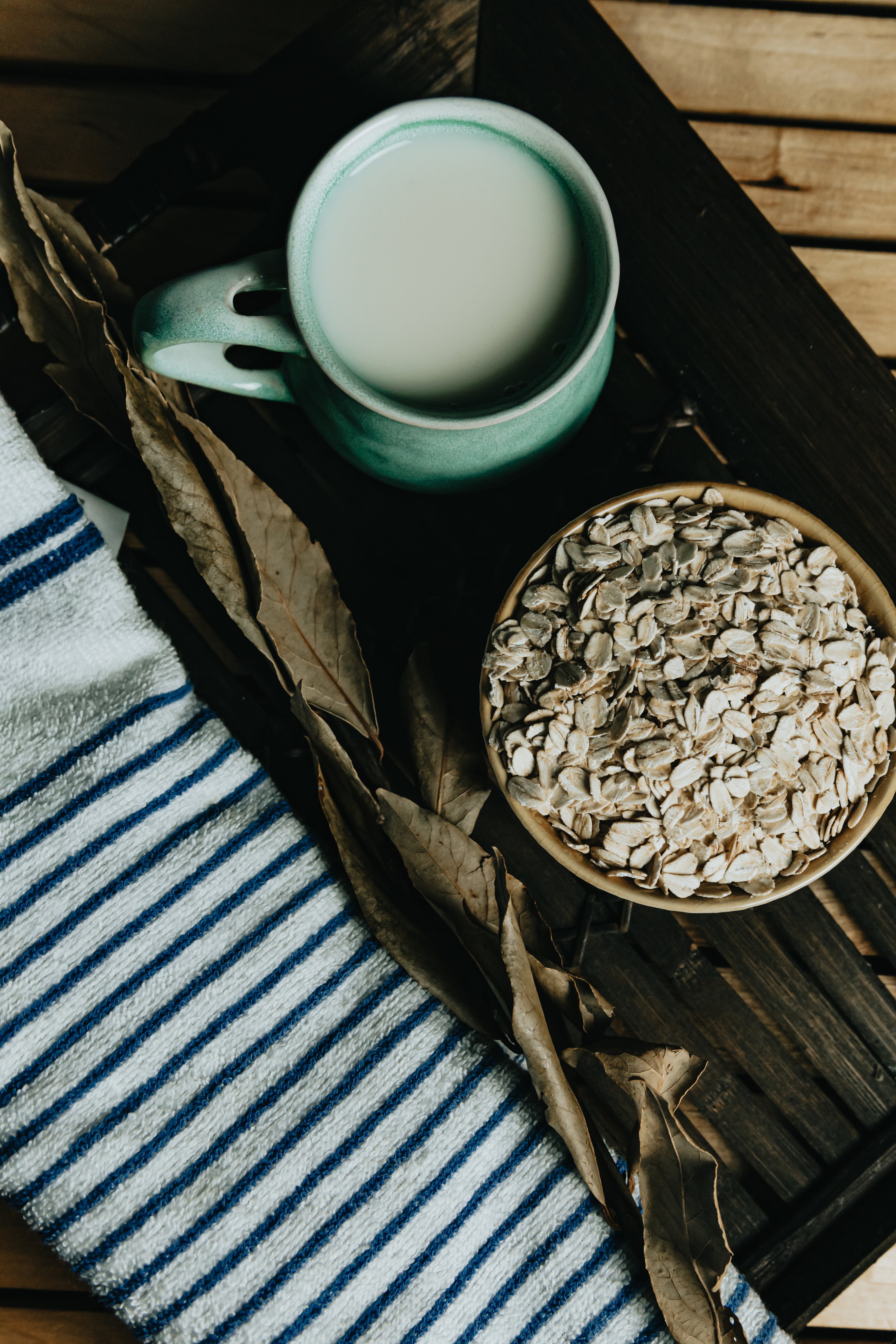 Flatlay of a bowl of oats, tea, and a towel